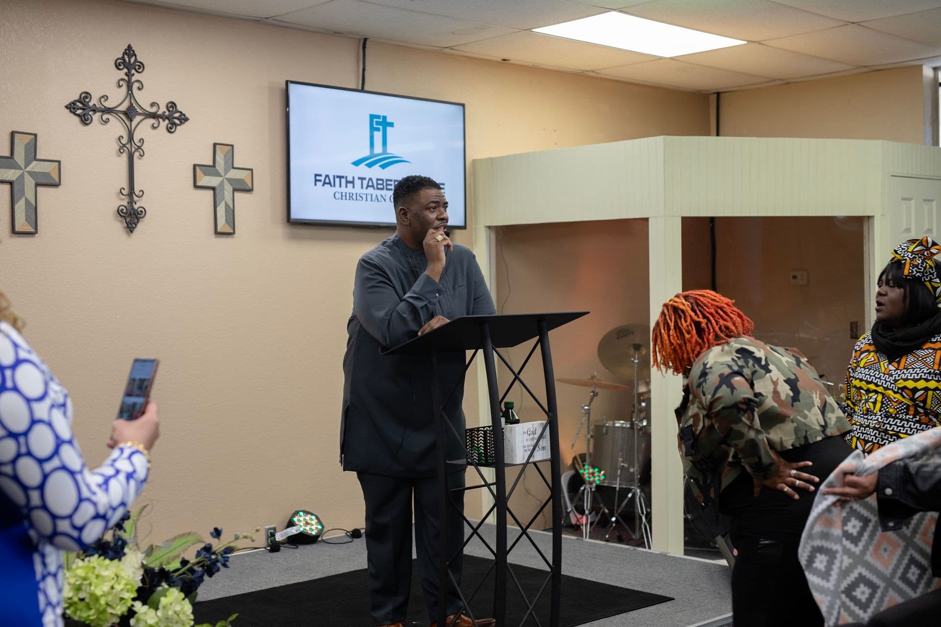 Pastor Jason White listening during worship as members praise God