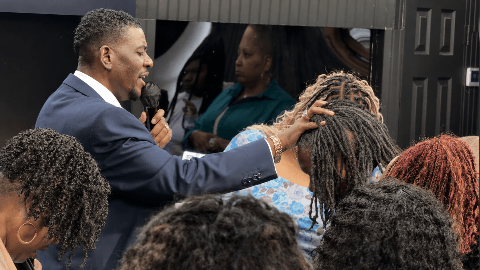 A pastor praying over members of the congregation during a service