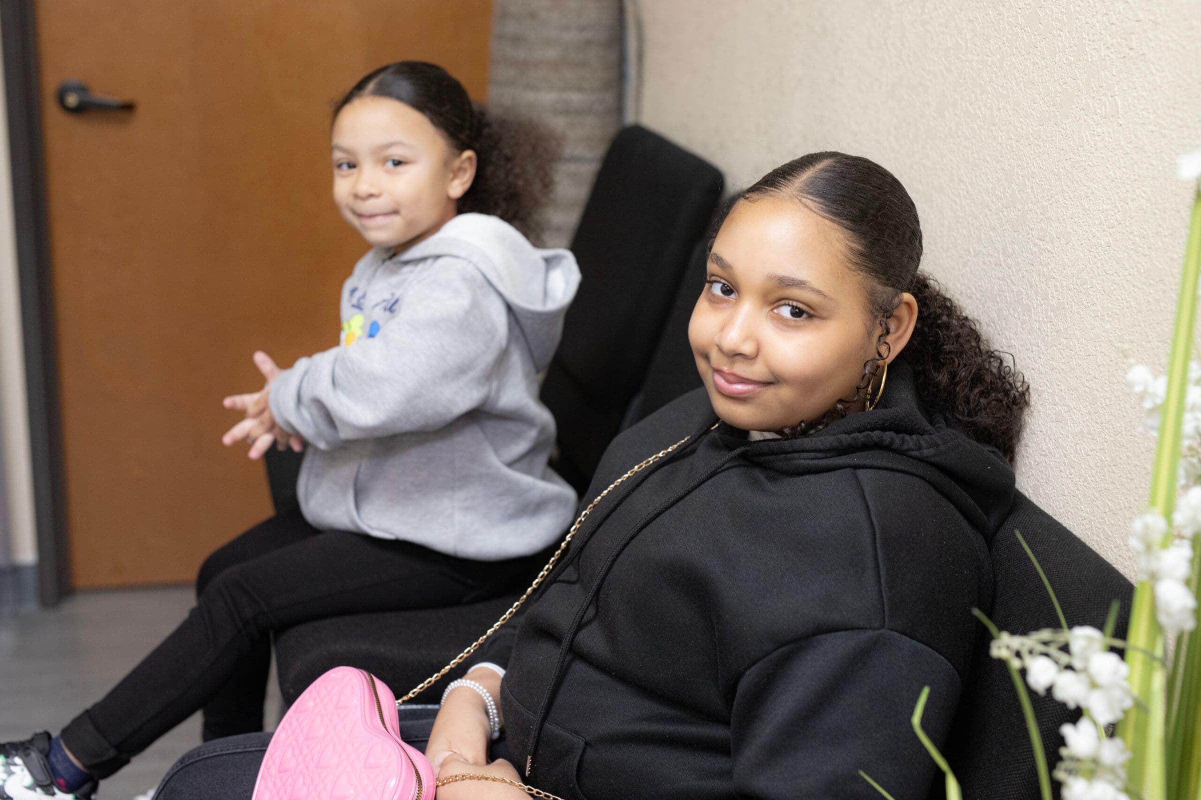 Two girls smiling from their seats during a Sunday service