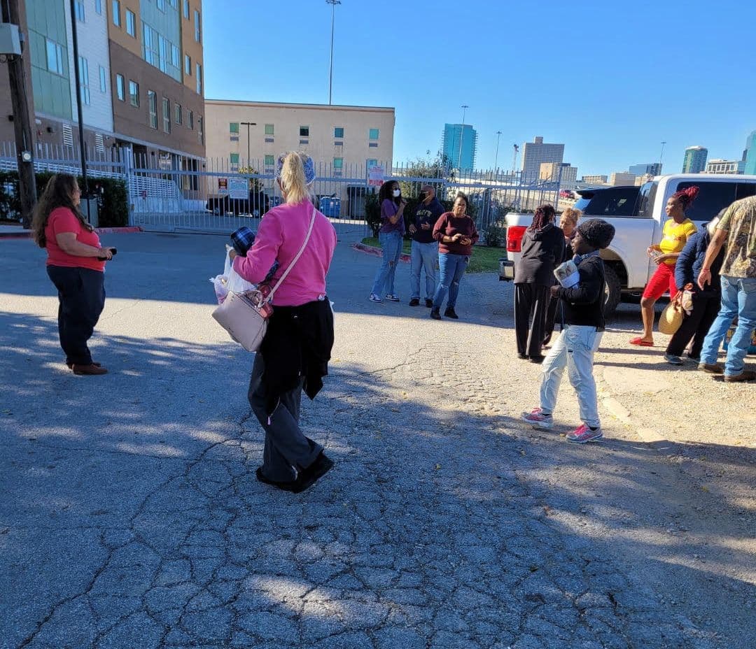 Volunteers walking through the crowd with bags of supplies during outreach