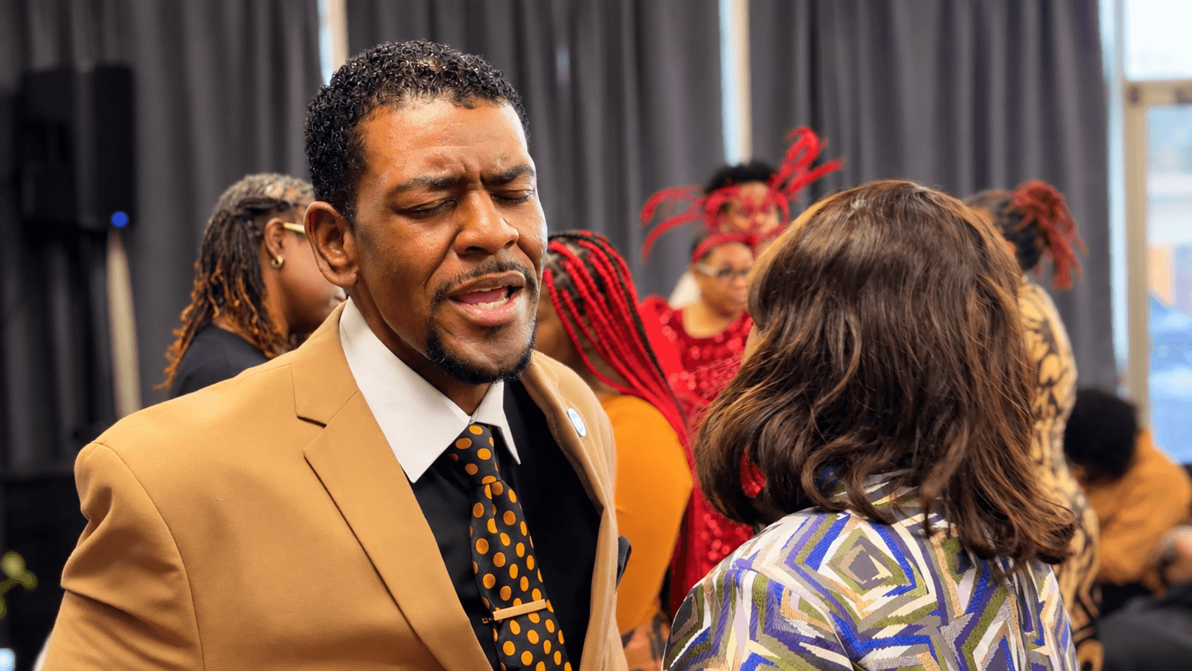 A worshipper lifting both hands in praise during a service at Faith Tabernacle Christian Church