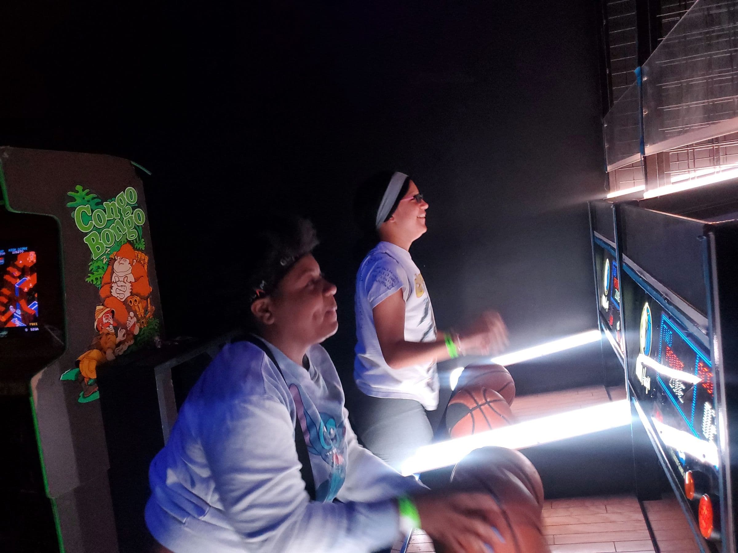 Students playing arcade games together on a youth outing