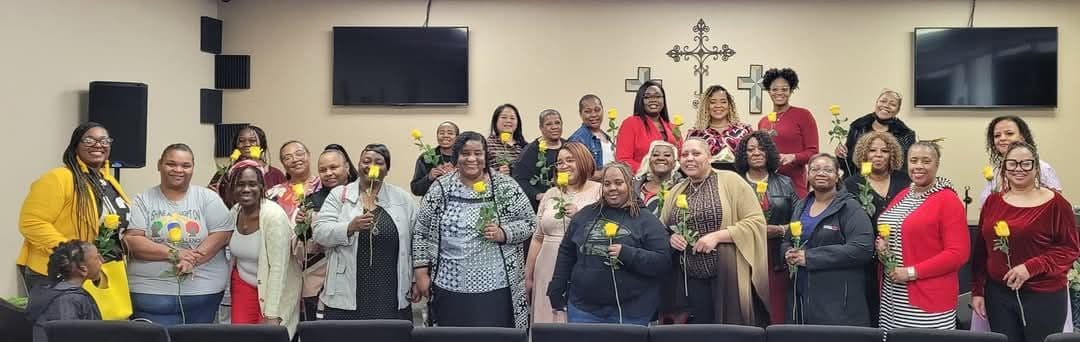 Members of Faith Tabernacle Christian Church gathered together with flowers after a service