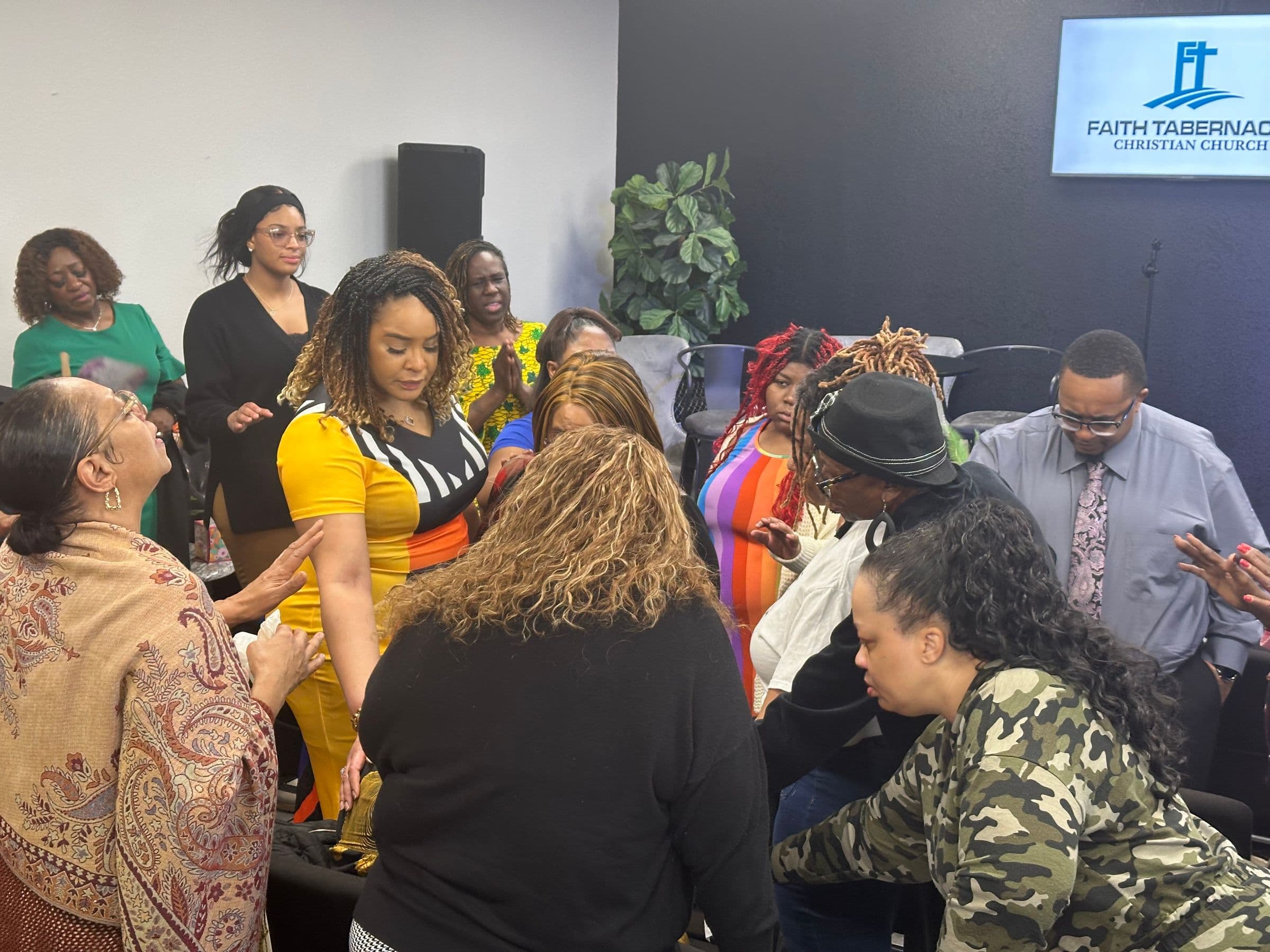 Members of Faith Tabernacle Christian Church praying together during worship
